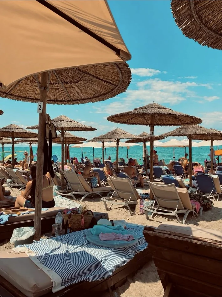 Real beach and sun umbrellas in front of ALYSEA
